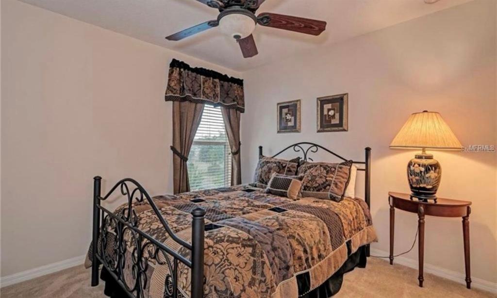 15108 Skip Jack Loop Lakewood Ranch, FL 34202 - Photo 20 of 23 a bed sitting in a bedroom next to a window