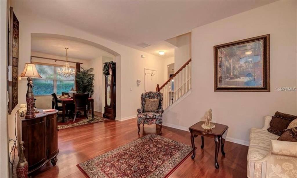 15108 Skip Jack Loop Lakewood Ranch, FL 34202 - Photo 4 of 23 a living room with furniture and wooden floor