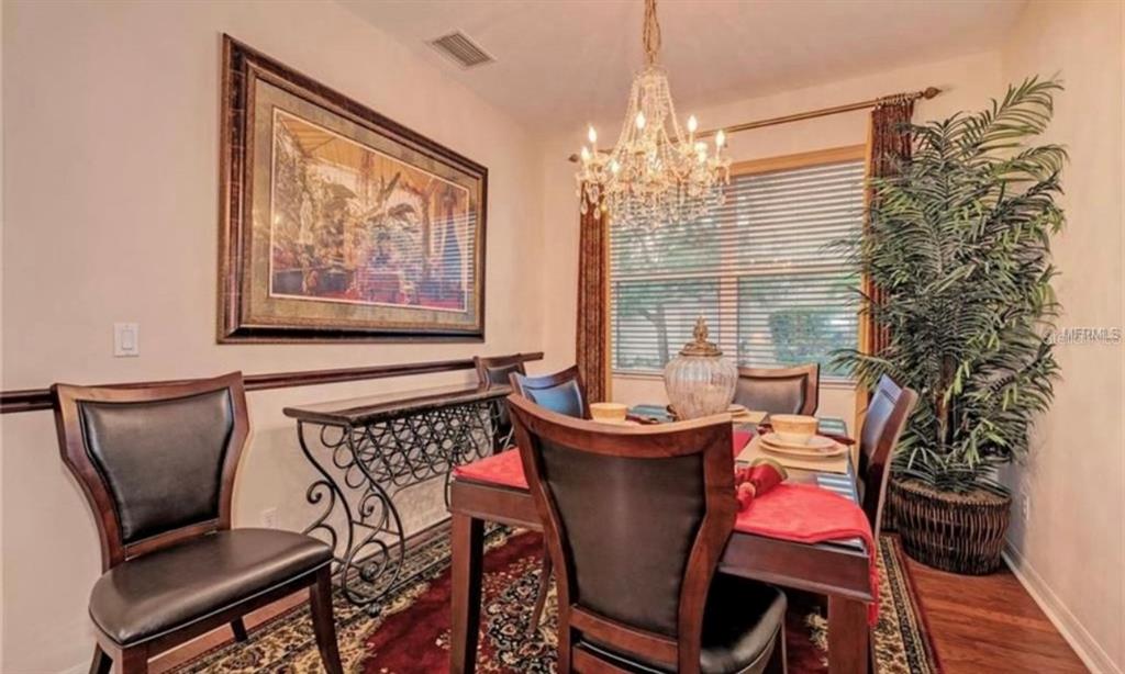 15108 Skip Jack Loop Lakewood Ranch, FL 34202 - Photo 5 of 23 a view of a dining room with furniture and chandelier