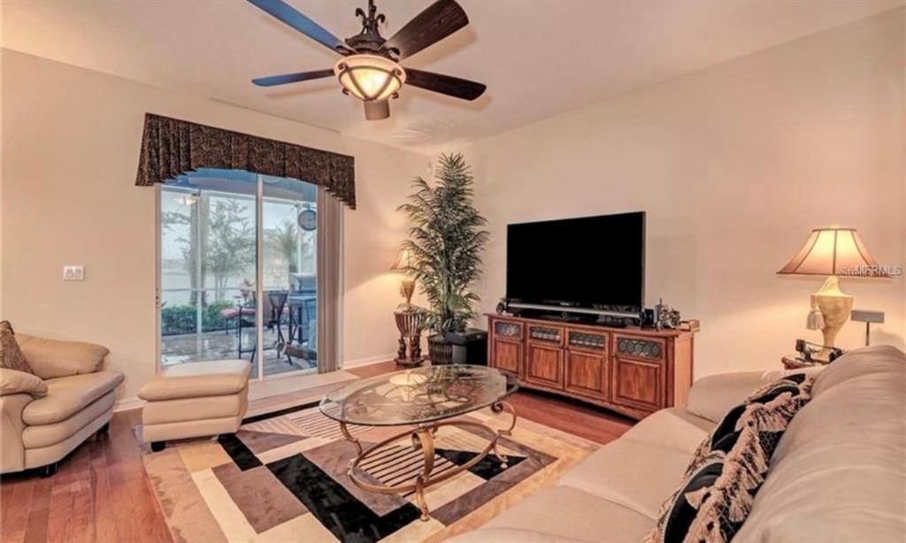 15108 Skip Jack Loop Lakewood Ranch, FL 34202 - Photo 6 of 23 a living room with furniture and a flat screen tv