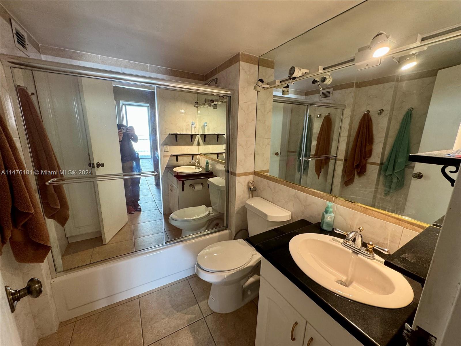 200 Southeast 15th Road, Unit 11F Miami, FL 33129 - Photo 12 of 22 a bathroom with a granite countertop sink toilet a mirror and shower