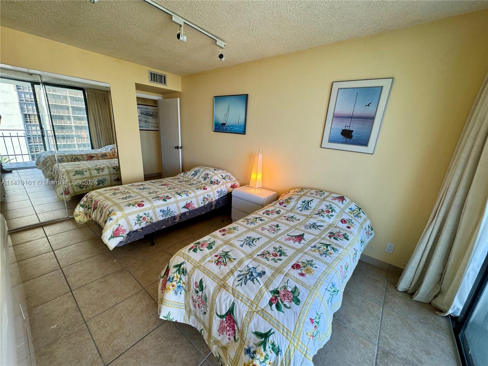 200 Southeast 15th Road, Unit 11F Miami, FL 33129 - Photo 14 of 22 a bedroom with two beds and a lamp