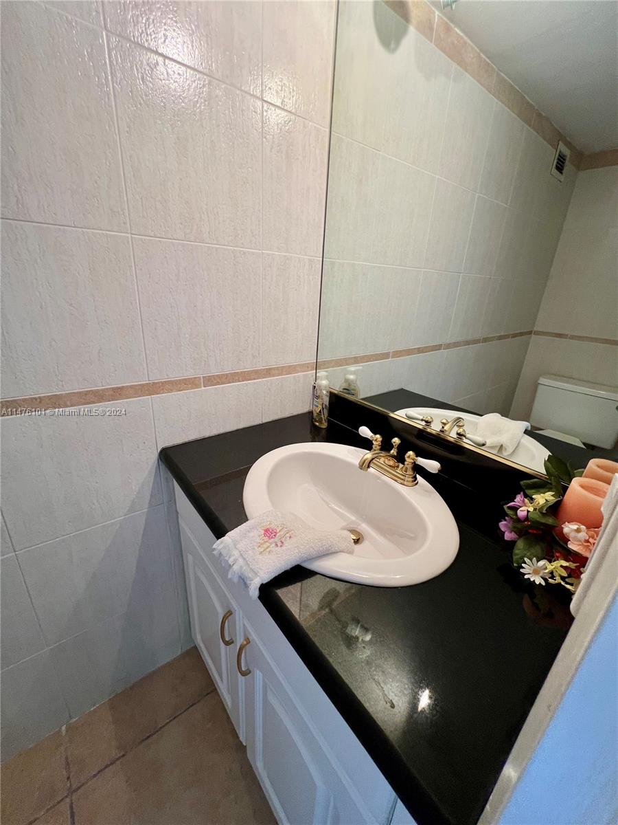 200 Southeast 15th Road, Unit 11F Miami, FL 33129 - Photo 19 of 22 a bathroom with a granite countertop sink and a mirror
