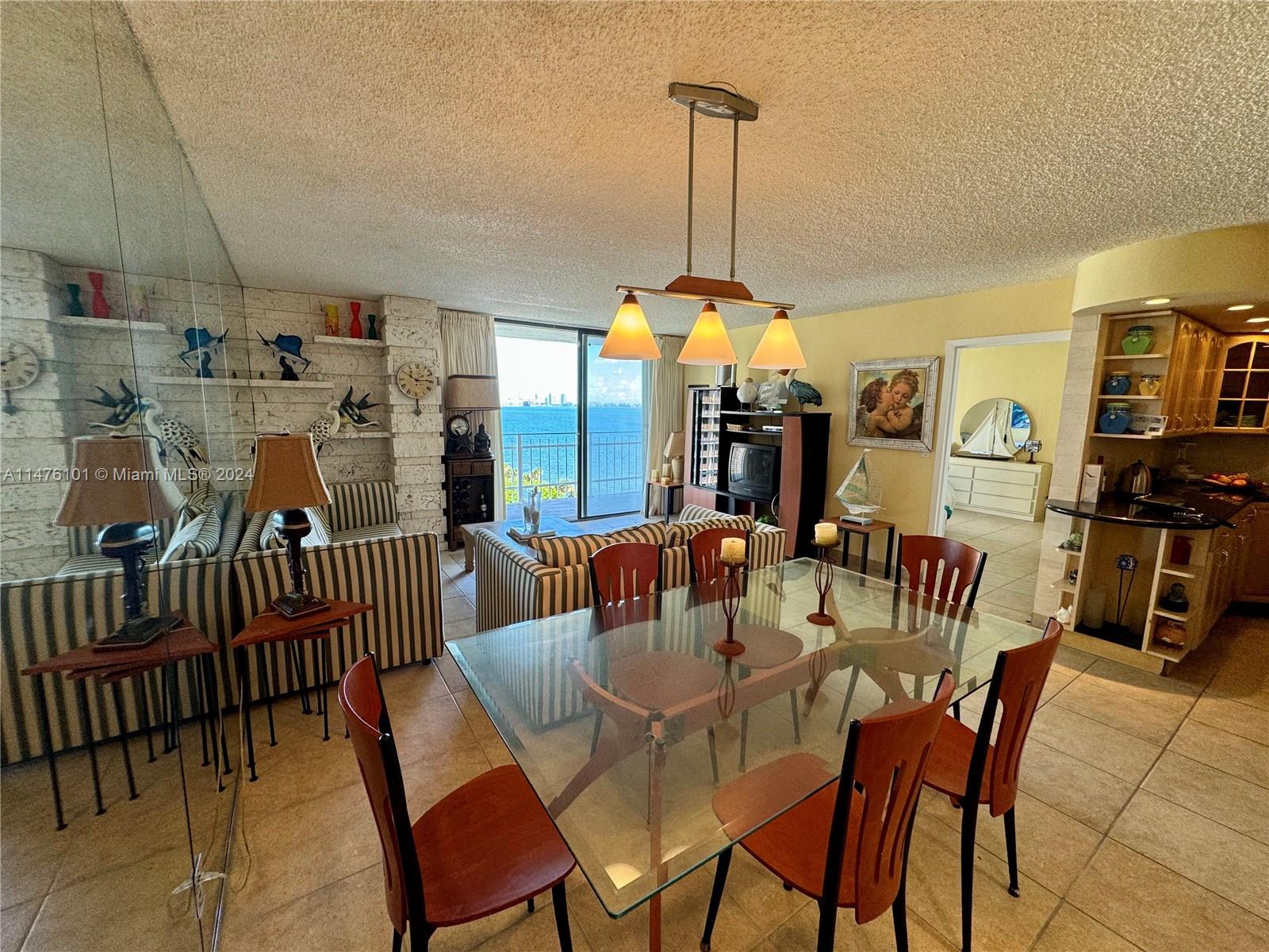 200 Southeast 15th Road, Unit 11F Miami, FL 33129 - Photo 5 of 22 a view of a dining room and livingroom with furniture wooden floor a chandelier
