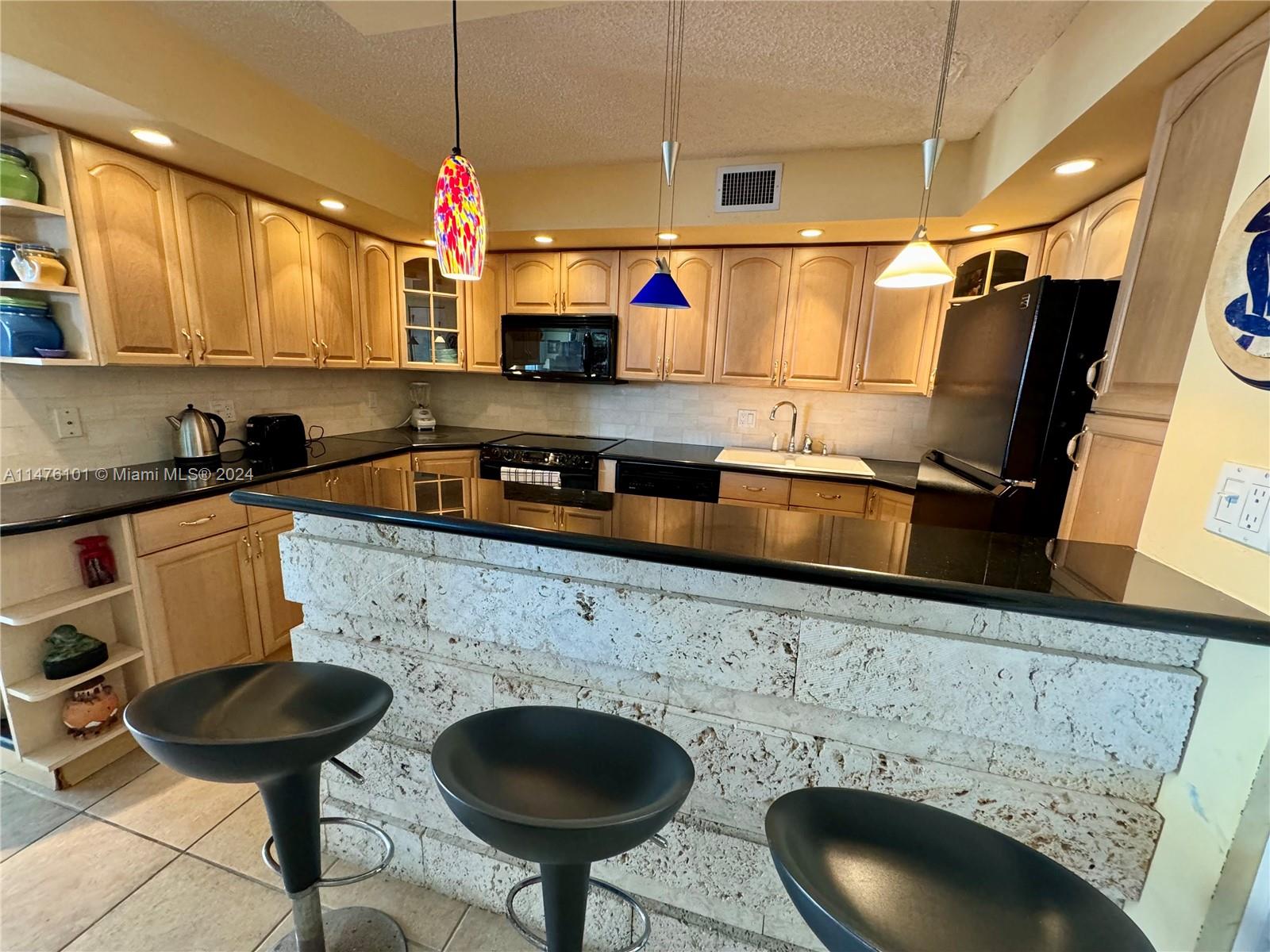 200 Southeast 15th Road, Unit 11F Miami, FL 33129 - Photo 9 of 22 a kitchen with a sink a stove and chairs