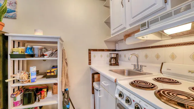 a kitchen with a stove and a white refrigerator