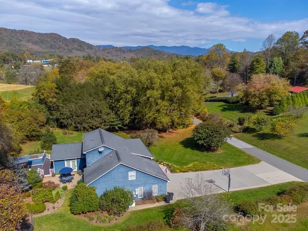 an aerial view of residential houses with outdoor space and trees