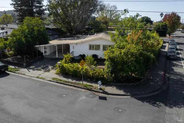 a front view of a house with a yard and potted plants