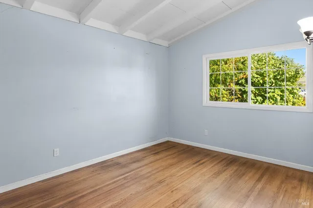 a view of a small space with wooden floor and a window