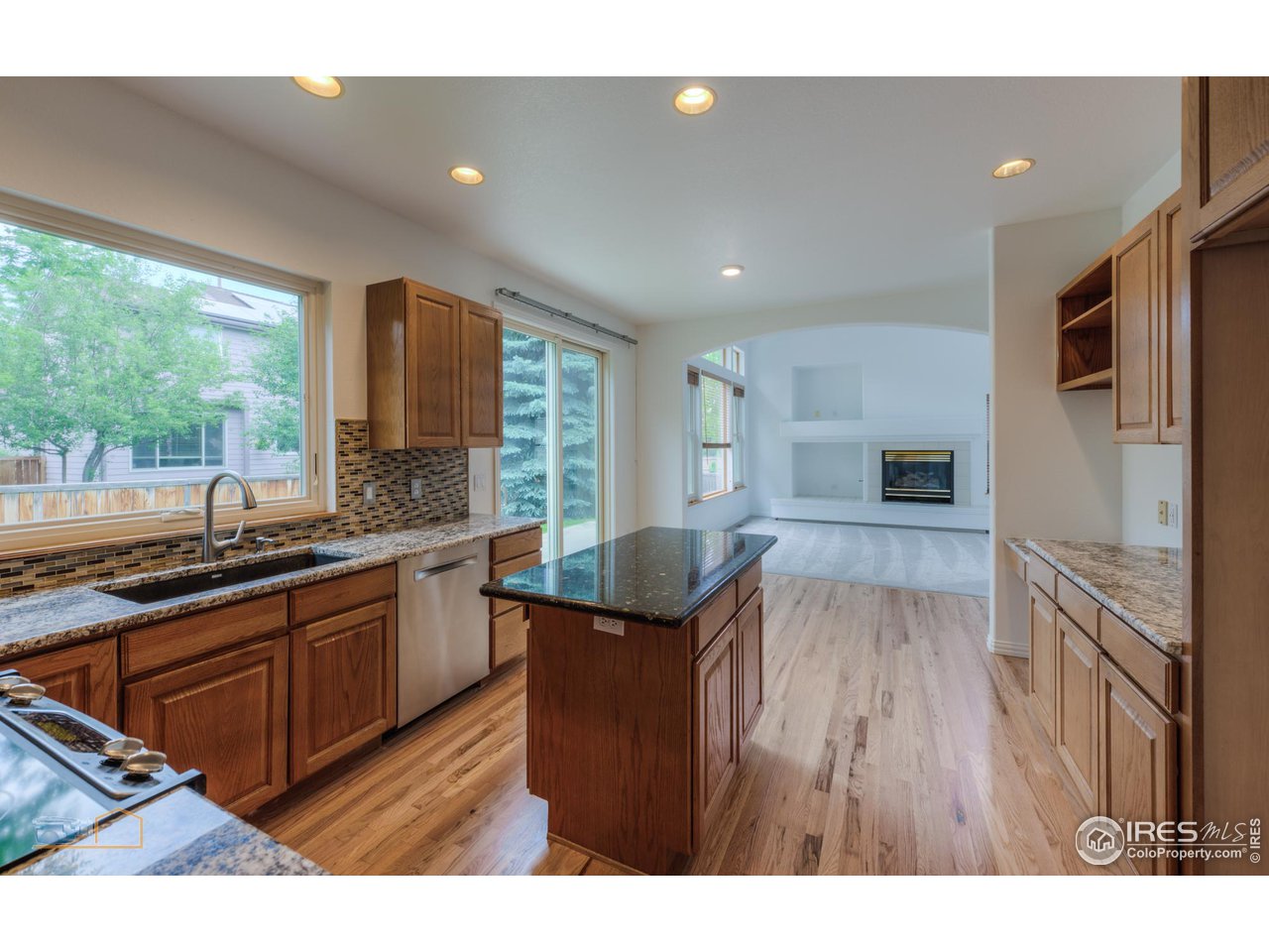 5933 Wellington Road Boulder, CO 80301 - Photo 5 of 39 a open kitchen with kitchen island granite countertop a sink stove and refrigerator