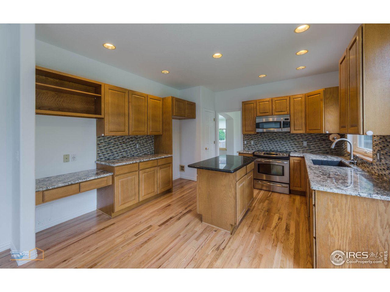5933 Wellington Road Boulder, CO 80301 - Photo 6 of 39 a kitchen with stainless steel appliances granite countertop a sink a stove top oven a counter space and cabinets