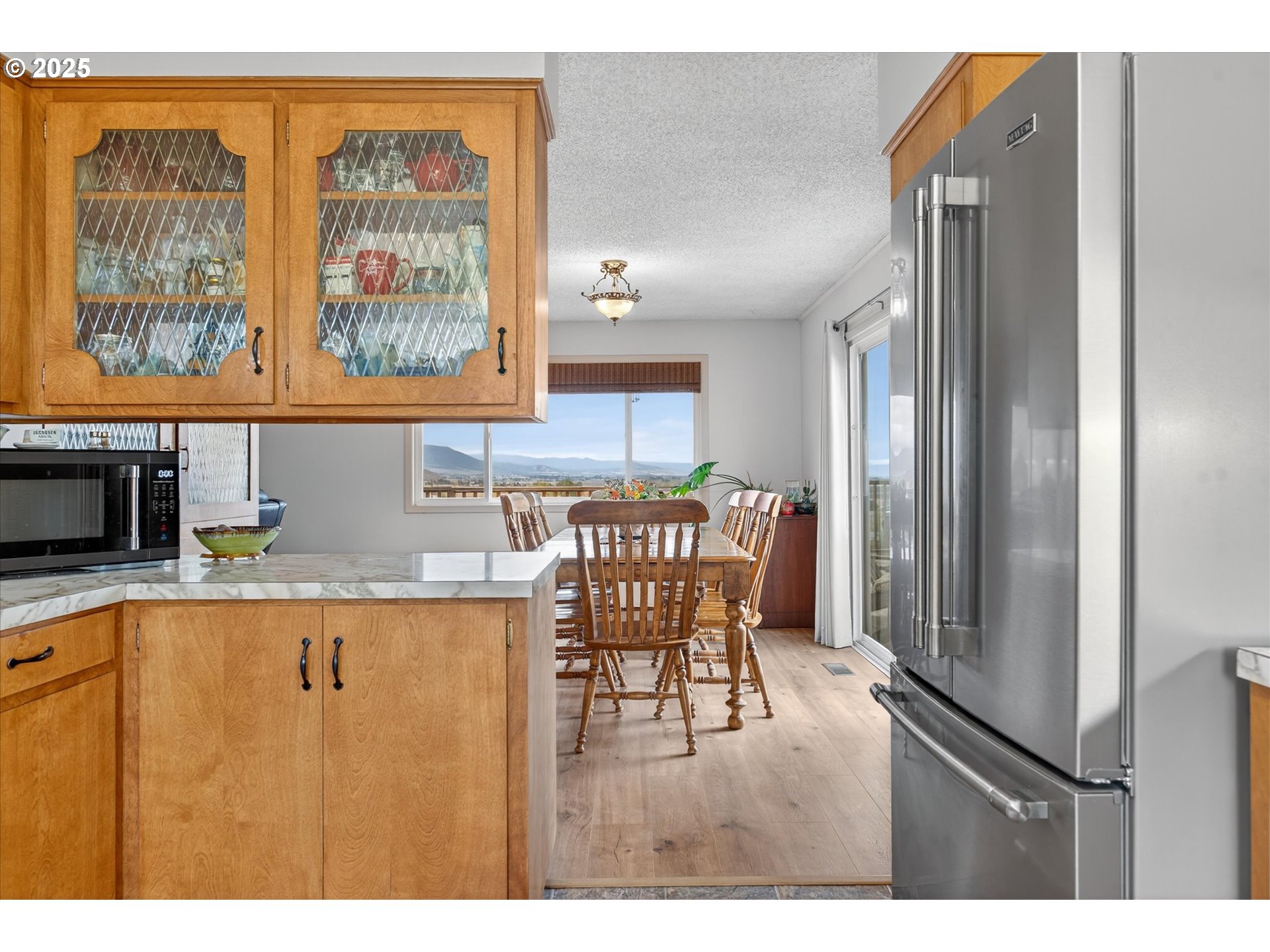 1025 17th Street Baker City, OR 97814 - Photo 23 of 48 a open kitchen with stainless steel appliances granite countertop a refrigerator a stove a dining table and chairs with wooden floor
