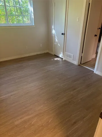 an empty room with wooden floor and window
