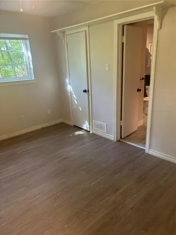 an empty room with wooden floor and a window