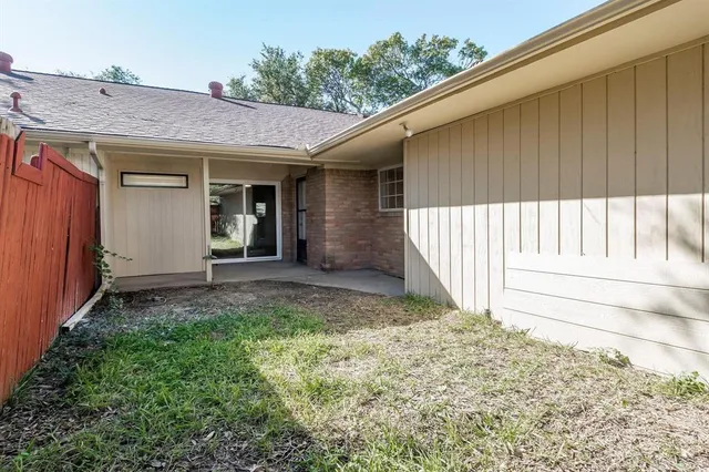 a view of a house with a small yard and wooden floor and fence