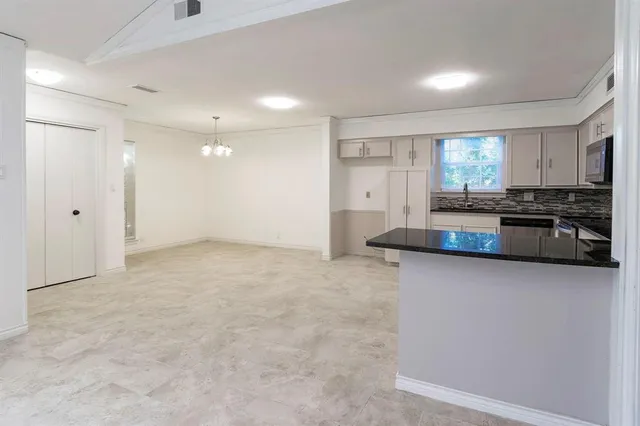 a view of kitchen with granite countertop cabinets and refrigerator