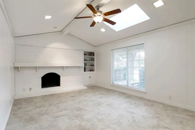 an empty room with fireplace and fan