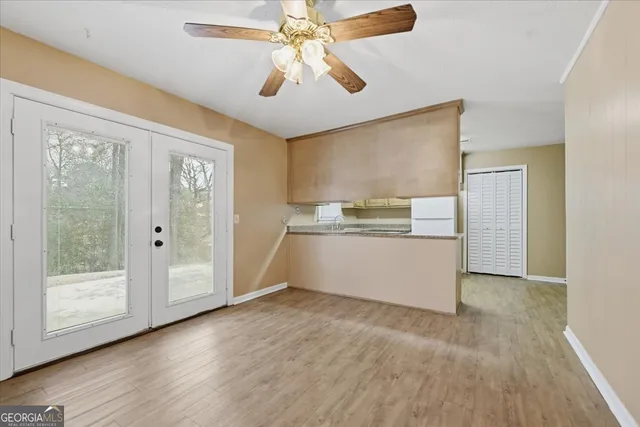 a view of kitchen with wooden floor a ceiling fan and window