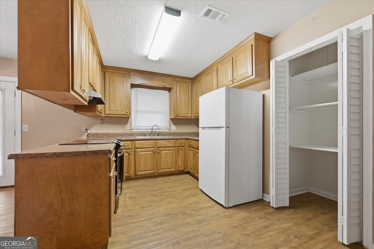 223 Randy Circle Warner Robins, GA 31088 - Photo 6 of 27 a kitchen with a refrigerator sink and cabinets