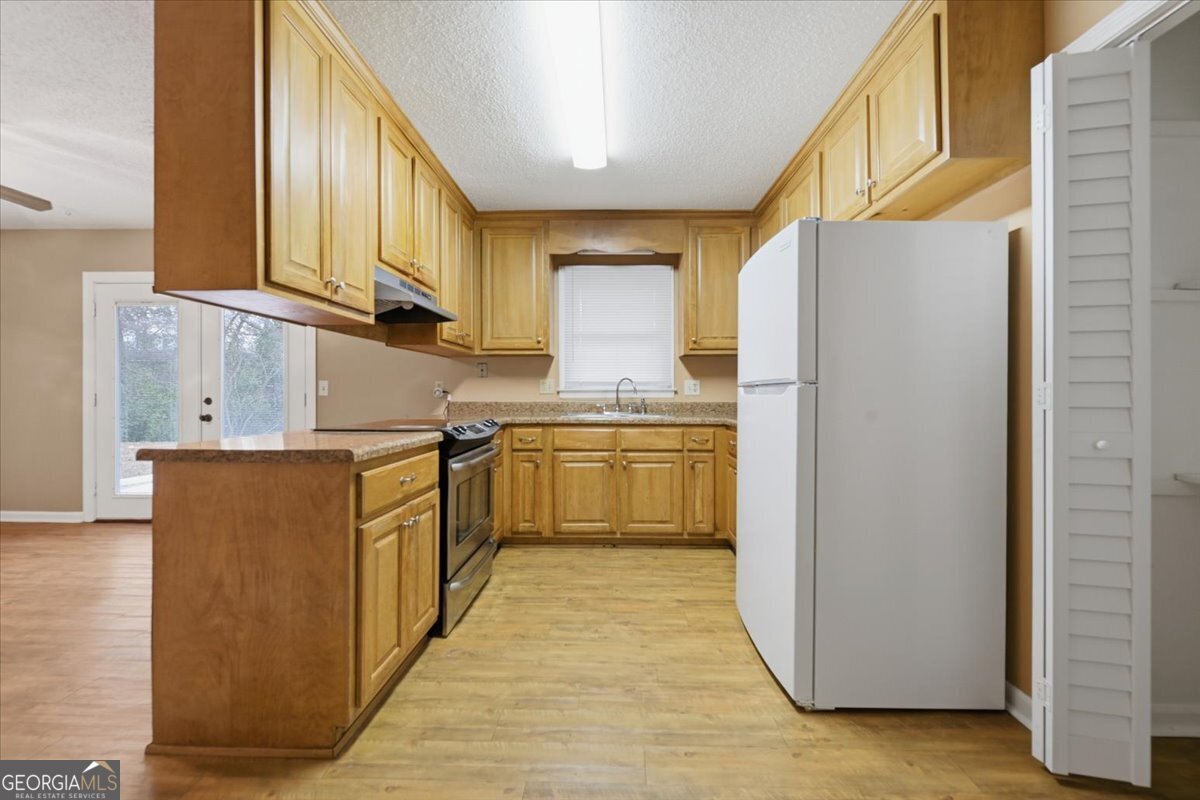 223 Randy Circle Warner Robins, GA 31088 - Photo 8 of 27 a kitchen with a sink a refrigerator and cabinets