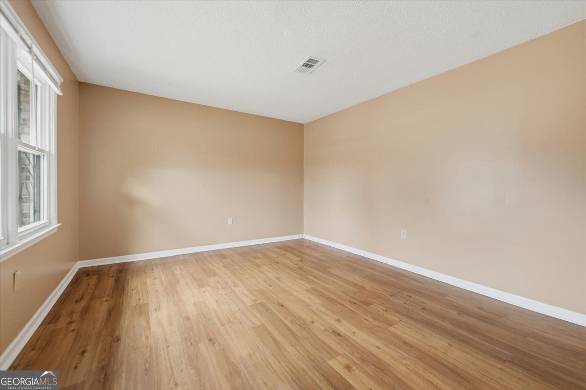 223 Randy Circle Warner Robins, GA 31088 - Photo 9 of 27 a view of an empty room with wooden floor and a window