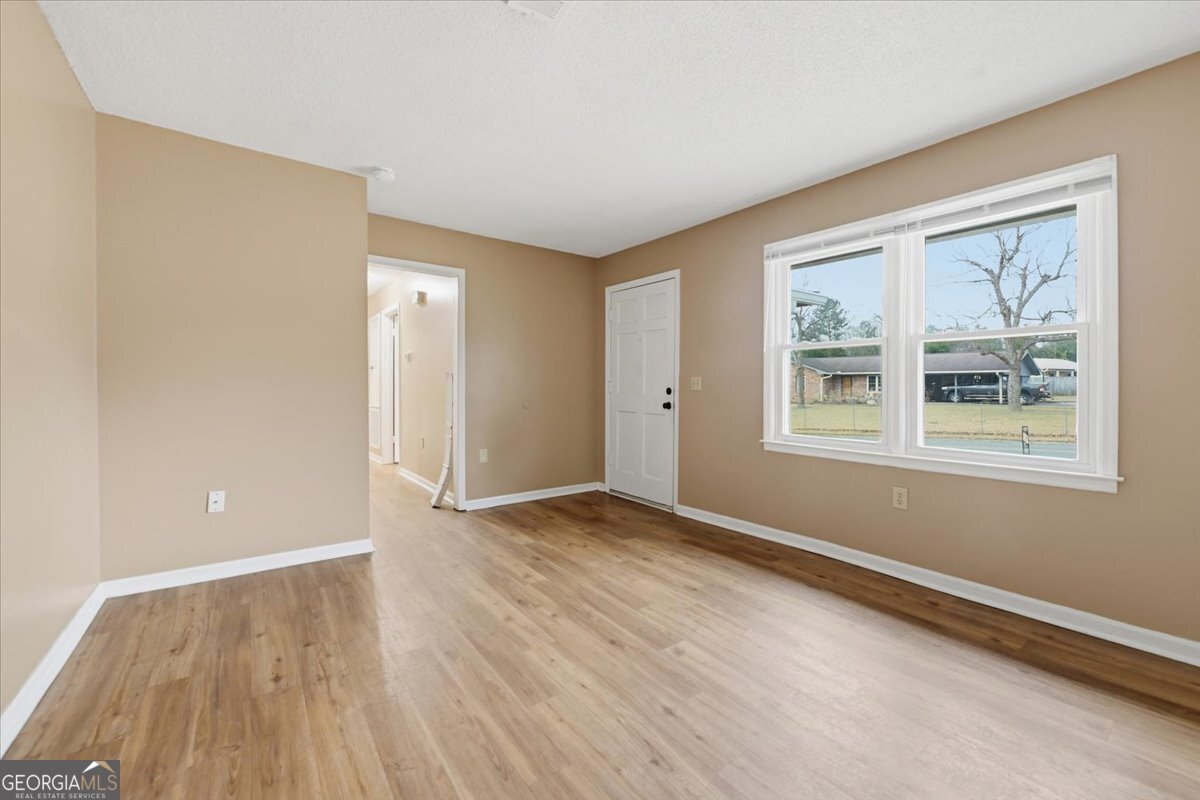 223 Randy Circle Warner Robins, GA 31088 - Photo 10 of 27 a view of an empty room with window and wooden floor
