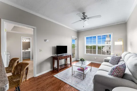 a living room with furniture a ceiling fan and a window