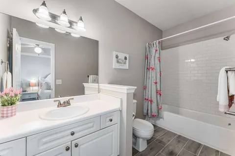 a bathroom with a sink a toilet a mirror and shower