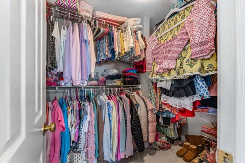 a view of walk in closet with clothes