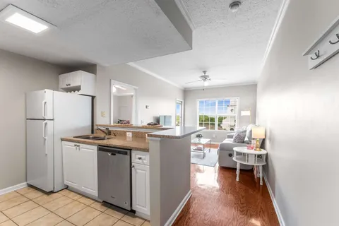 a kitchen with a sink a refrigerator and chairs