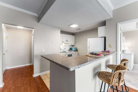 a kitchen with a stove a refrigerator and wooden floor