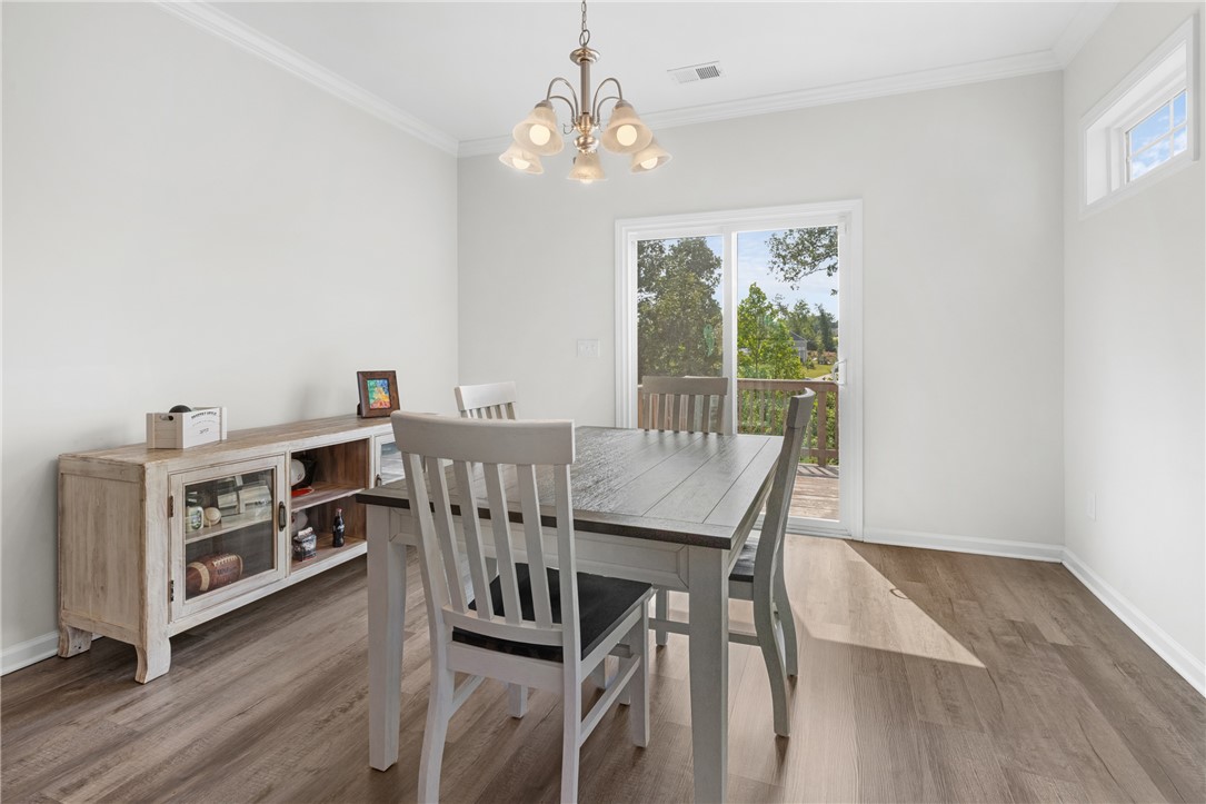 768 Rocky Ridge Circle Seneca, SC 29678 - Photo 15 of 30 A well-lit dining area featuring crown molding and resilient flooring, perfect for daily meals or entertaining.