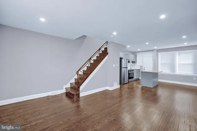 a view of a kitchen with wooden floor and stairs