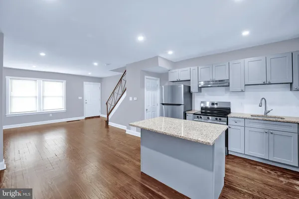 a kitchen with stainless steel appliances a sink a stove a refrigerator and cabinets