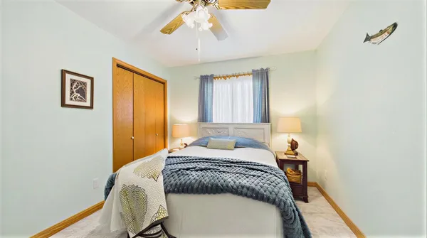 a bedroom with a bed dresser and a large window
