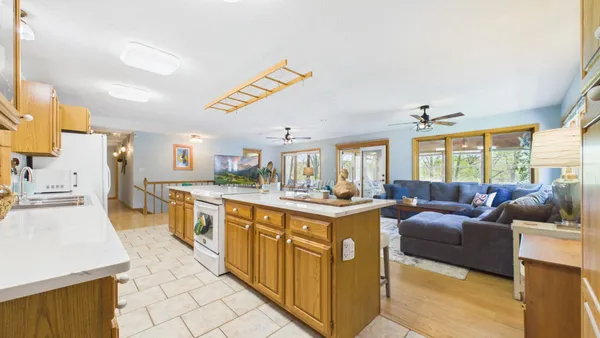 a view of a dining room with furniture a chandelier and wooden floor