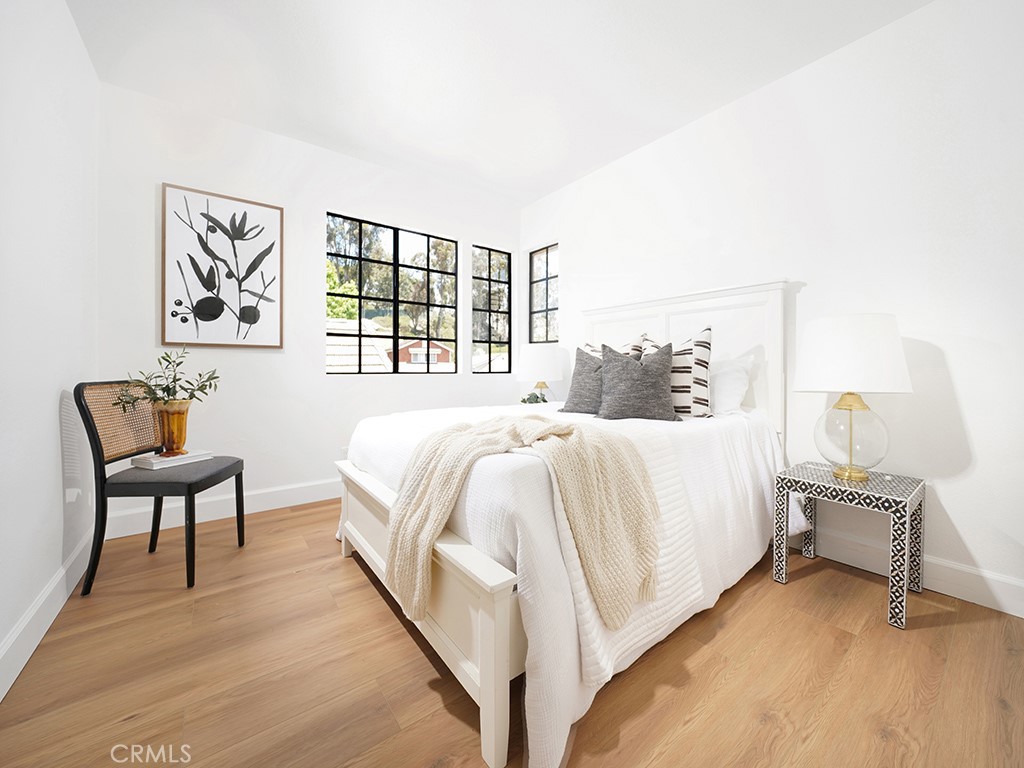 24912 Danamaple Dana Point, CA 92629 - Photo 19 of 36 a spacious bedroom with a bed and a chair