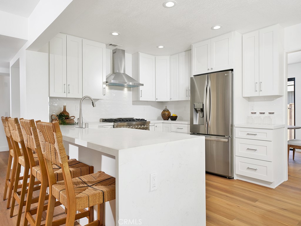 24912 Danamaple Dana Point, CA 92629 - Photo 7 of 36 a kitchen with a refrigerator a stove top oven and white kitchen island