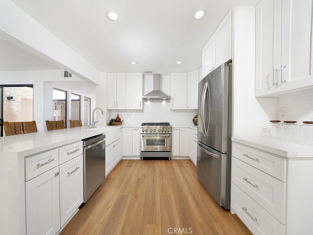 24912 Danamaple Dana Point, CA 92629 - Photo 8 of 36 a kitchen with white cabinets and stainless steel appliances