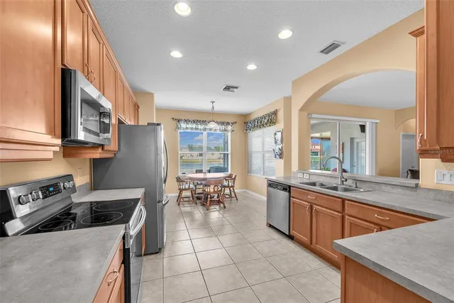 a kitchen with stainless steel appliances granite countertop a stove a sink and a refrigerator