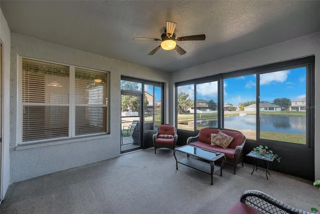 a living room with furniture and a large window with balcony view