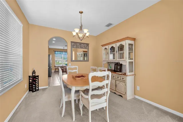a view of a dining room with furniture and chandelier