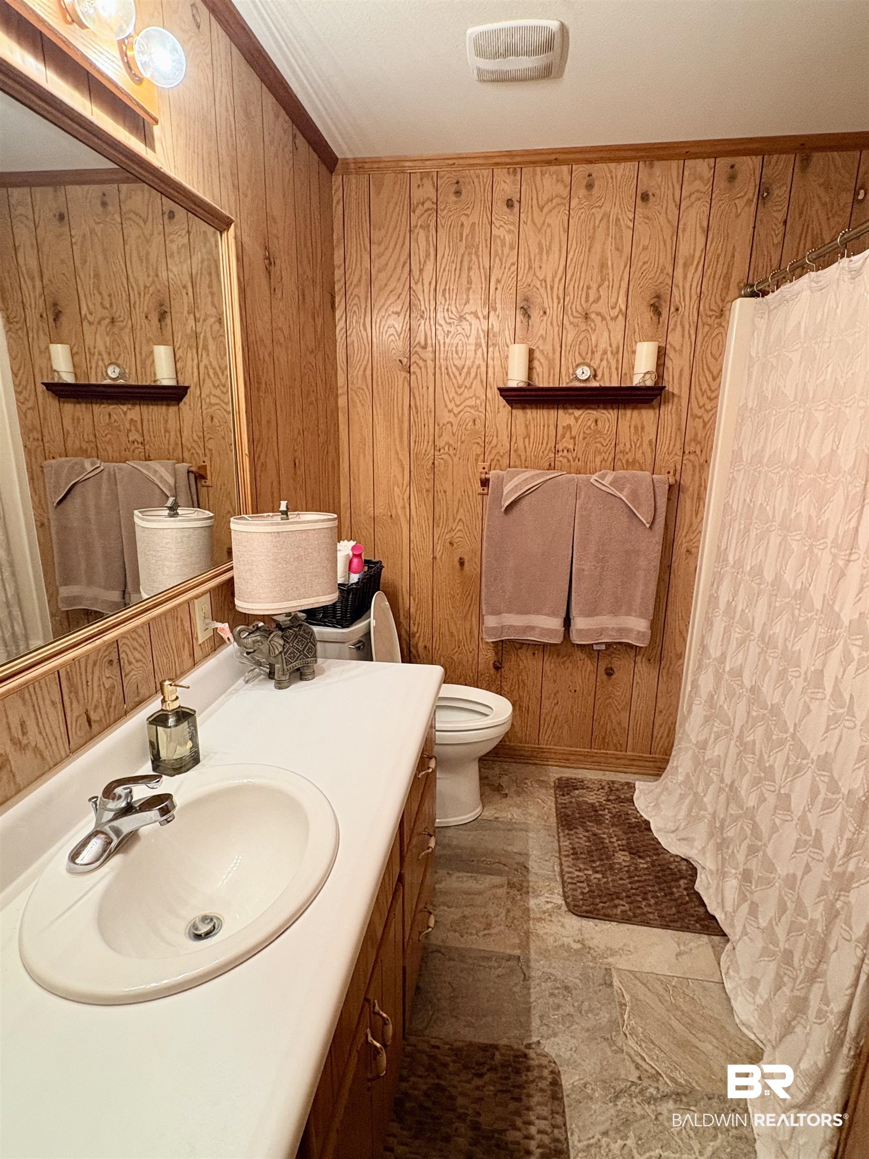 44 Ridge Road Castleberry, AL 36432 - Photo 11 of 33 Bathroom with wooden walls, vanity, curtained shower, ornamental molding, and light stone finish flooring