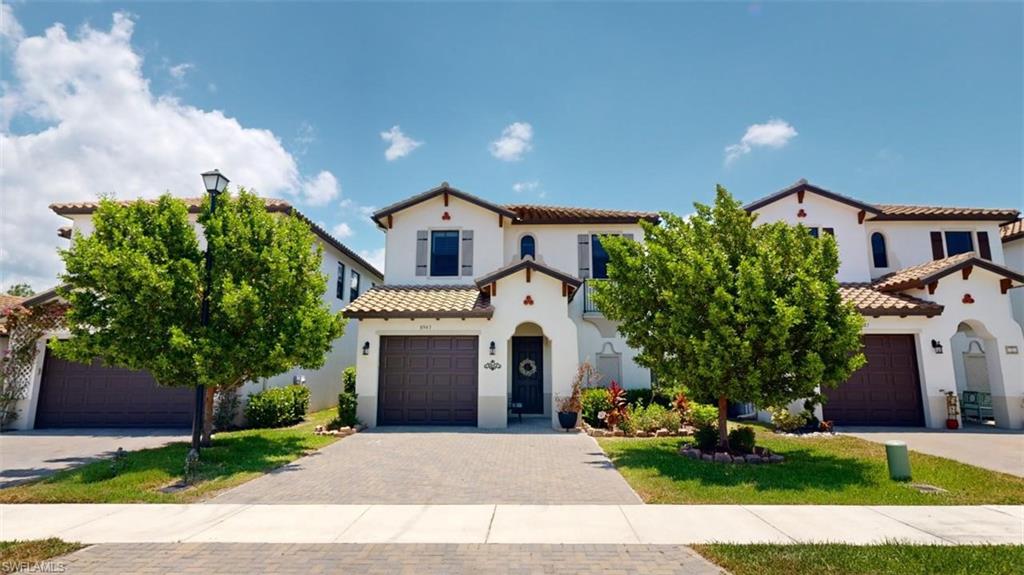 a front view of a house with a yard and a garage