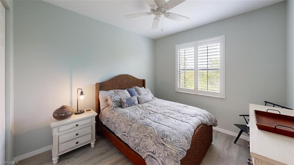 8943 Madrid Circle Naples, FL 34104 - Photo 10 of 13 a bedroom with a bed and a chandelier