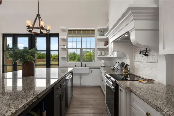 a kitchen with a sink a counter top space and stainless steel appliances