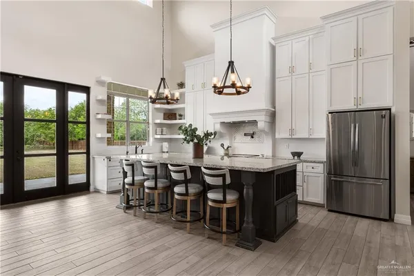 a kitchen with stainless steel appliances granite countertop a sink a stove and refrigerator with wooden floor
