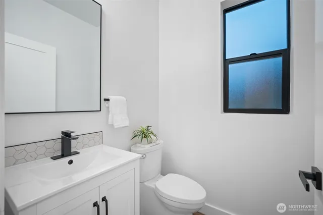 a bathroom with a sink a toilet and mirror