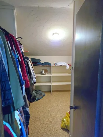 a view of walk in closet with clothes