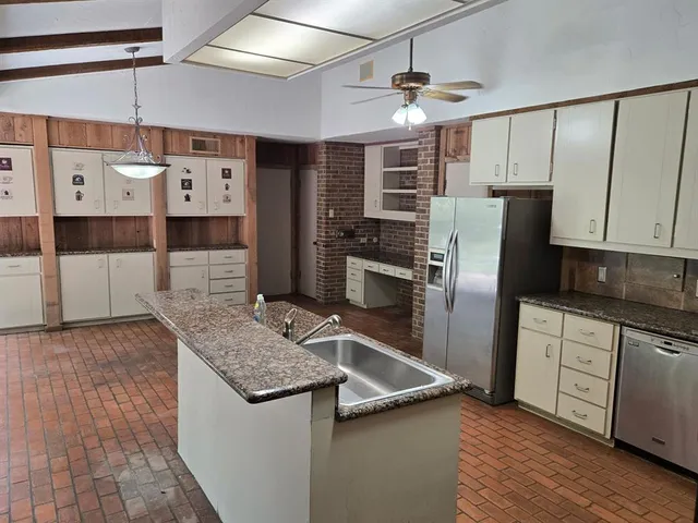 a kitchen with granite countertop white cabinets and stainless steel appliances